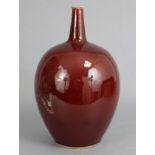 A 20th century ox-blood glazed ovoid pottery vase with tall narrow neck, 13¾” high (chip to neck-