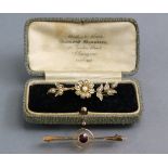 A 9ct. gold propeller-shaped bar brooch set small ruby to the centre, 1¾” long; & a 9ct. gold flower