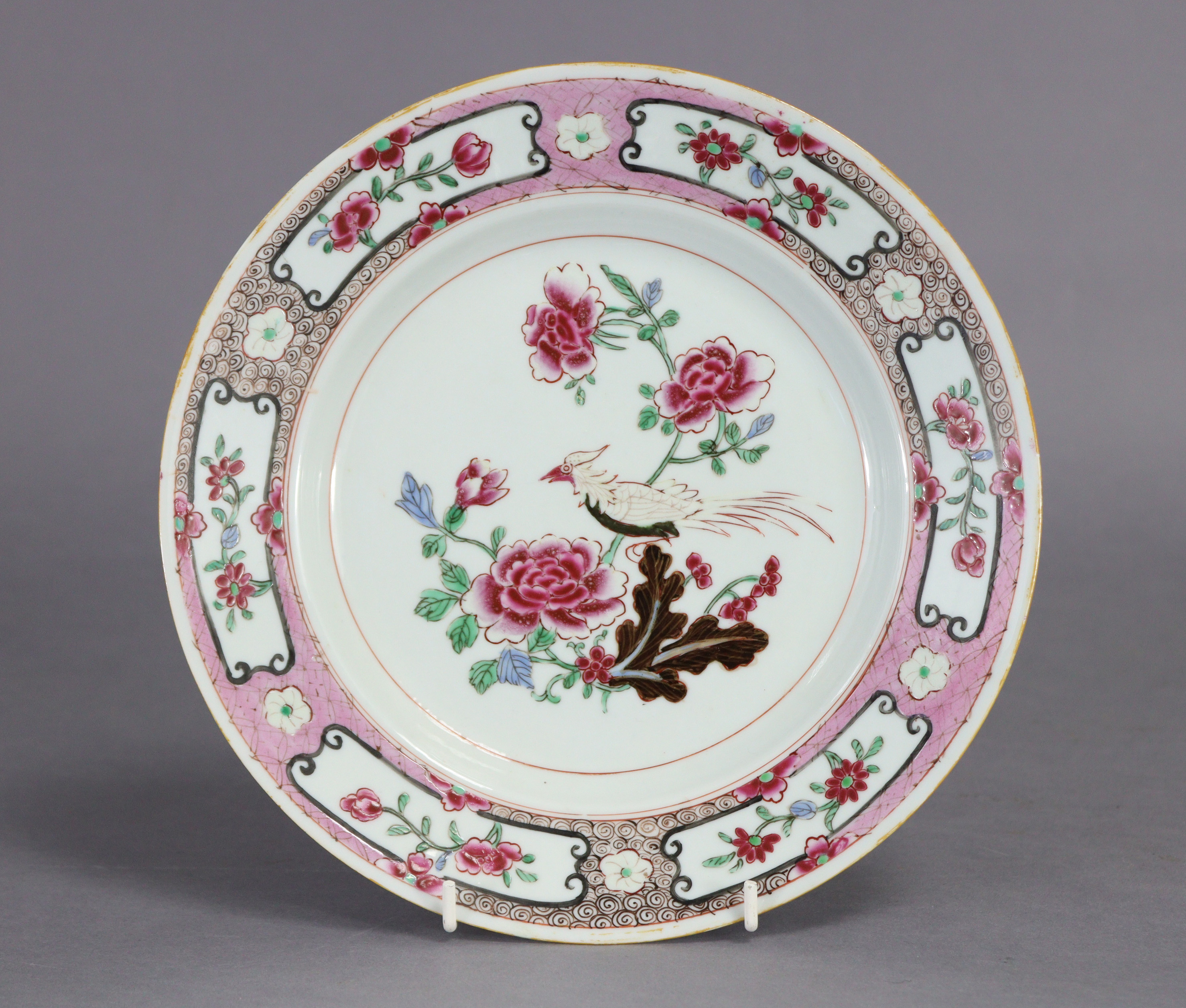 Two 18th century Chinese porcelain plates, each decorated in famille rose enamels with a bird on