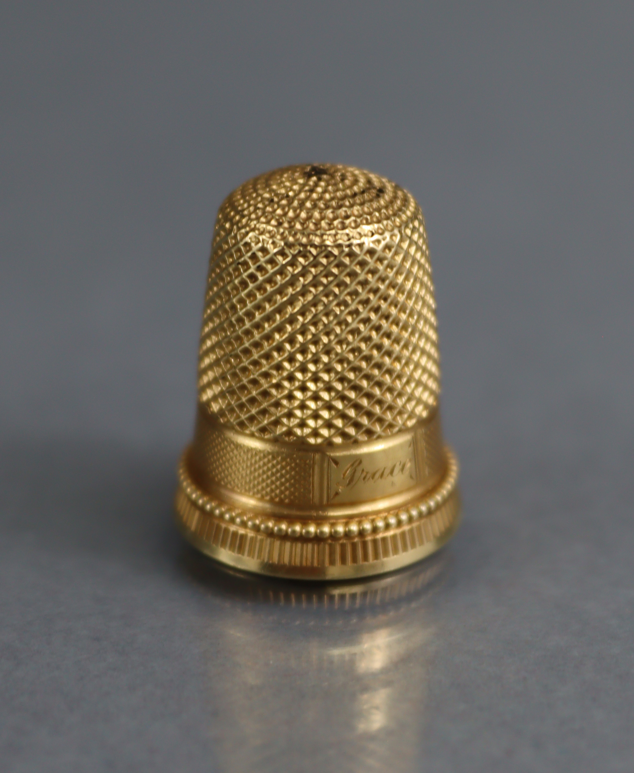 A GOLD THIMBLE with engraved inscription “Grace”, ¾” high, un-marked (6.8gm); in TIFFANY & Co. - Image 2 of 5