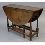 An early 18th century joined oak gate-leg table, the oval top with drop leaves, fitted end drawer