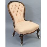 A Victorian spoon-back nursing chair with foliate carved walnut frame, upholstered floral damask,