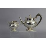 A George V silver teapot of ovoid form, with vase finial to the flat hinge lid, gadrooned rims, on