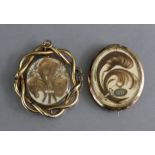 A Victorian yellow metal hollow-work oval brooch with entwined foliate border, the revolving