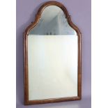 A Queen Anne style shaped rectangular wall mirror in walnut veneered frame, 27” x 16”.