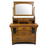 AN ARTS & CRAFTS OAK DRESSING CHEST BY LIBERTY & Co., with arched bevelled swing mirror above the