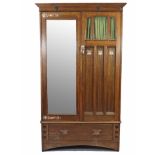 AN ARTS & CRAFTS OAK WARDROBE BY LIBERTY & Co., with moulded cornice & applied heart motifs, the