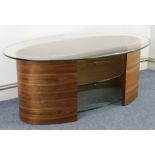 A contemporary walnut-finish oval low side table with tempered-glass top above two tempered-glass