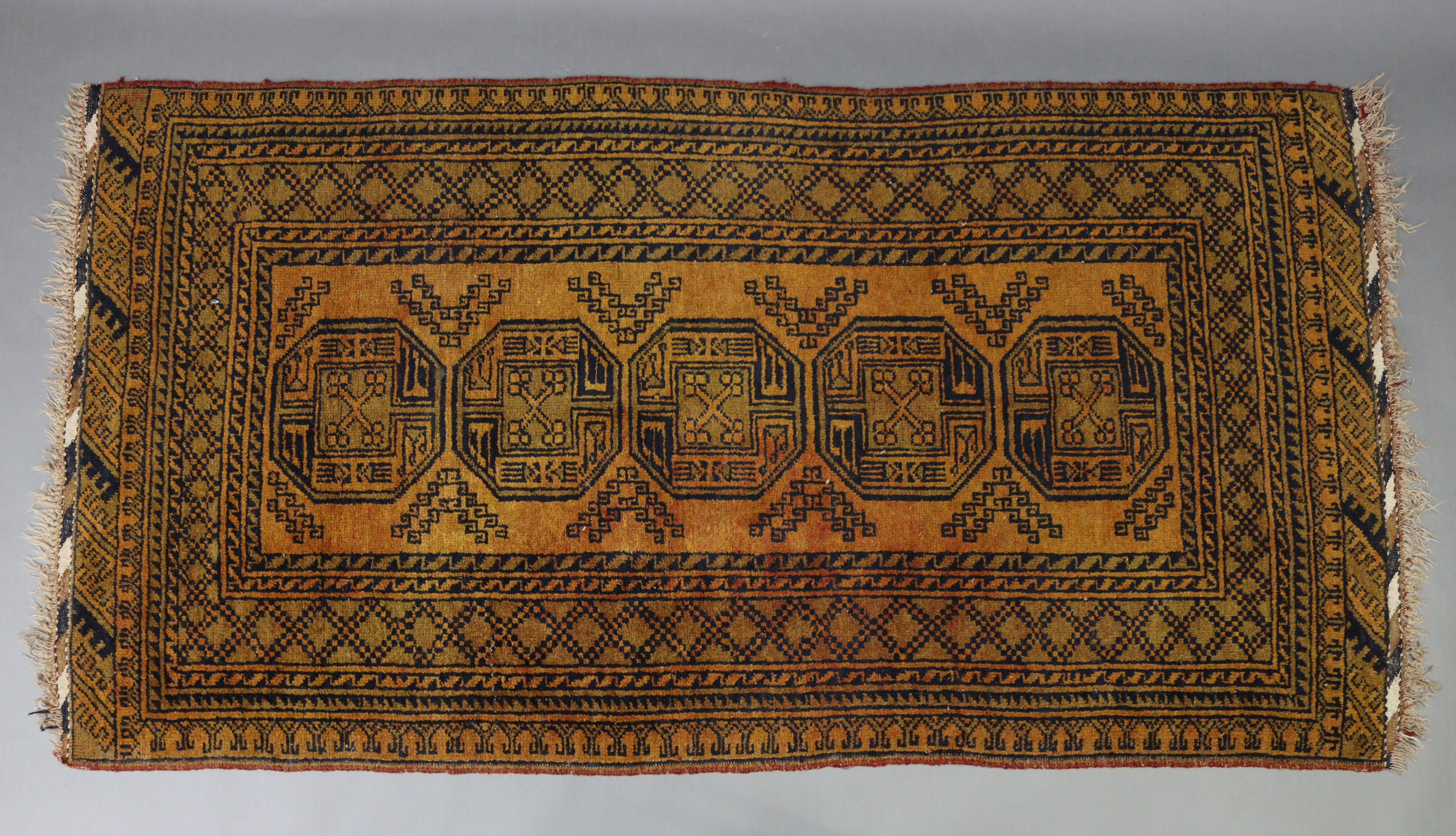 An Afghan rug of orange & black ground & with five ghuls to centre within a multiple border, 80” x