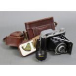 An Agilux folding camera with case; together with two walking canes.