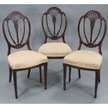 A set of four early 19th century Hepplewhite style dining chairs with carved & pierced foliate