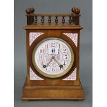 An early 20th century mantel clock with pink & white floral decorated enamel dial, with striking