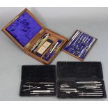 A set of steel drawing instruments in fitted mahogany case; together with two part sets of drawing