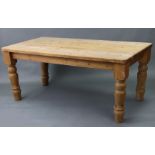 A pine kitchen table with rounded corners to the rectangular top, & on four turned legs, 72” x 36”.