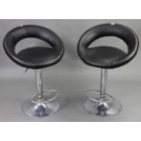A pair of chrome-finish bar stools with black vinyl seats & backs.