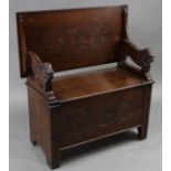 A reproduction carved oak monk’s bench with rectangular sliding top, with lion supports, & with