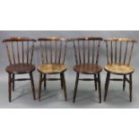 A set of four spindle-back kitchen chairs with circular hard seats, &on turned legs with spindle