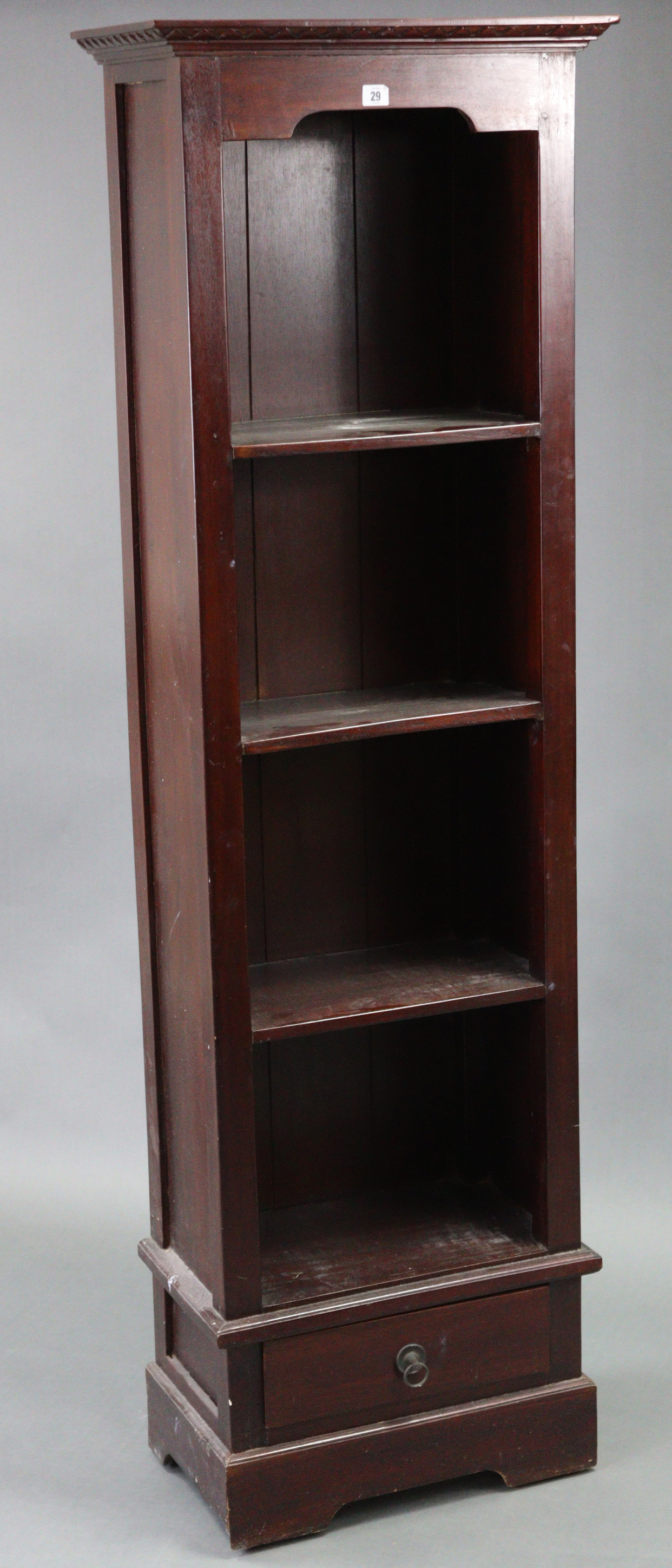 A hardwood tall standing open four-tier bookcase, fitted with a long drawer below & on shaped plinth