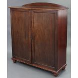 An early Victorian mahogany bookcase with arched top, fitted three adjustable shelves enclosed by