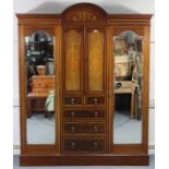 An Edwardian marquetry-inlaid three section wardrobe with shaped cornice, with cupboard to centre