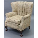 A buttoned-back easy chair upholstered multi-coloured floral material, & on short cabriole legs with