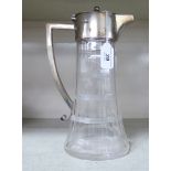 A late Victorian facet cut glass wine jug of tapered, oval form with an applied silver collar,