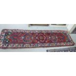 A Caucasian runner with repeating stylised designs on a multi-coloured ground 38'' x 123'' S