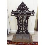 A late Victorian painted cast iron stickstand with a pierced backplate and a detachable drip tray