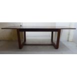 An Uniflex, Gunther Hoffstead rosewood draw leaf dining table, raised on opposing U-shaped supports,