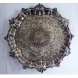 A George III silver waiter with a decoratively cast piecrust border and later engraved designs,