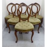 A set of six late Victorian walnut, foliate carved, balloon back dining chairs,