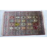 A silk rug, decorated with twenty repeating rectangular inner panels,