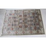 A silk rug, decorated with repeating rectangular inner panels, bordered by floral,