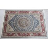 A silk rug, decorated with a graduated central serpentine outlined starburst motif,