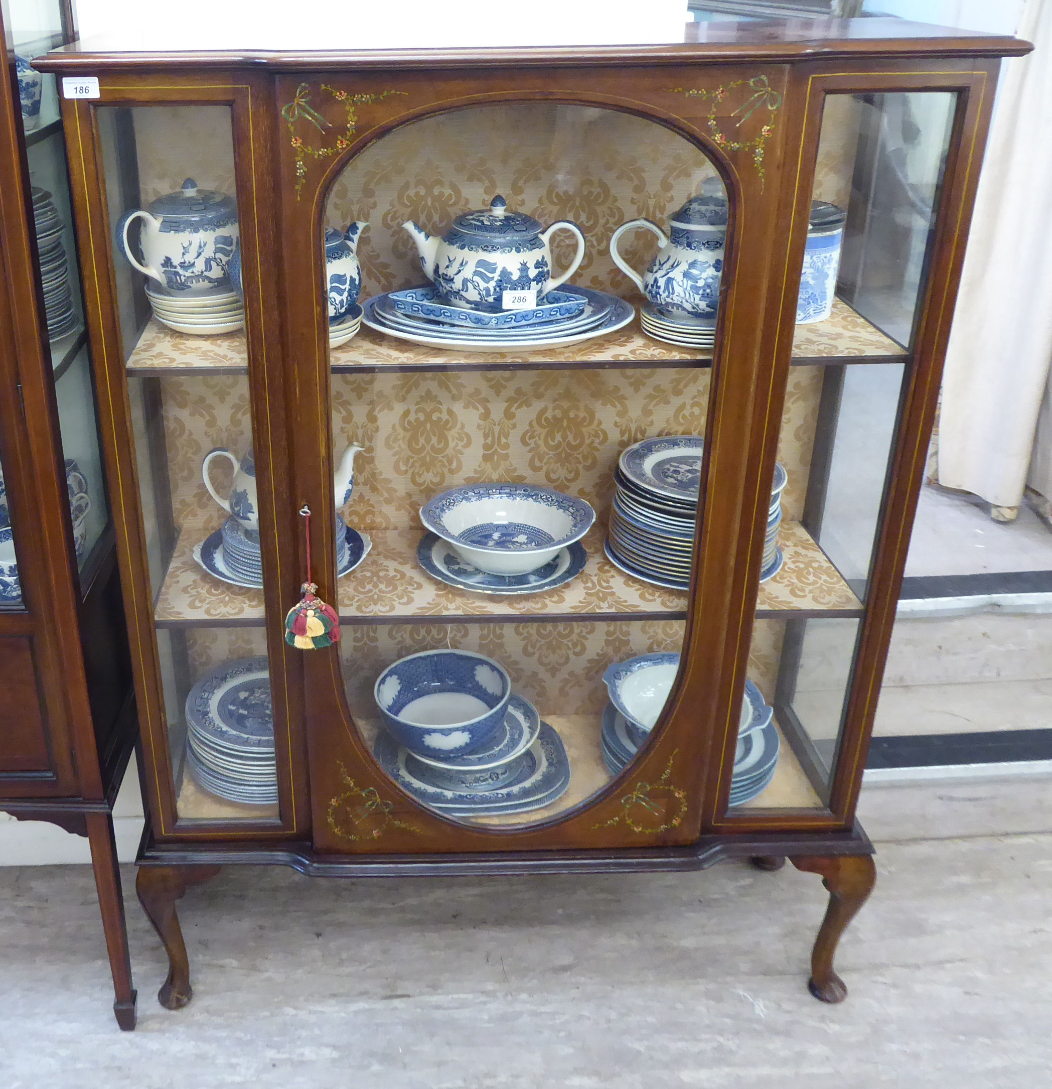 An Edwardian mahogany breakfront fully glazed display cabinet with floral painted ornament,