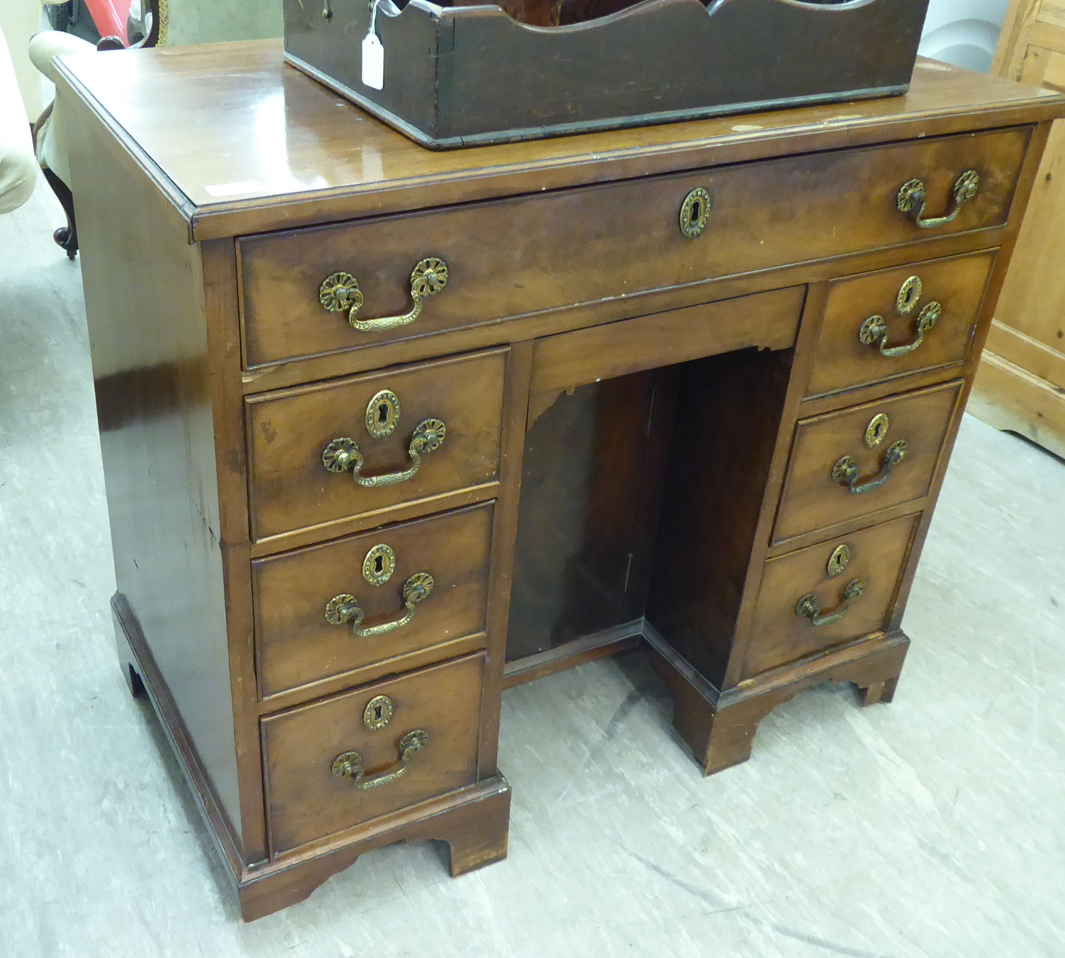 An early 19thC mahogany kneehole desk, comprising an arrangement of eight drawers,