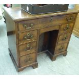 An early 19thC mahogany kneehole desk, comprising an arrangement of eight drawers,