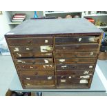 An early 20thC plywood chest with two banks of eight drawers, some with fabric lining,