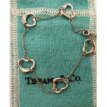 A Tiffany & Co platinum bracelet, the fine chain set with five heart shaped motifs,
