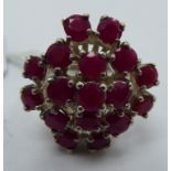 A silver coloured metal ruby set cluster ring 11