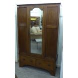 An Edwardian string inlaid mahogany wardrobe, the central, bevelled mirror, panelled door,