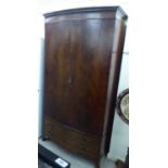 An early 20thC mahogany bow front wardrobe,