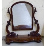A late Victorian mahogany dressing table mirror, the arched plate set between foliate moulded,