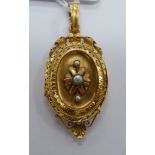 An 'antique' gold oval locket, set with three seed pearls,