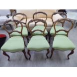 A set of six late Victorian walnut framed and carved balloon back dining chairs,