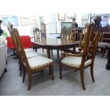 A Waring & Gillows oval walnut dining table, raised on square,