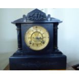 A 1940s slate cased mantle clock of architectural form; the movement faced by a Roman dial,