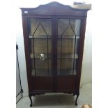 An Edwardian string inlaid mahogany display cabinet with a pair of glazed doors,