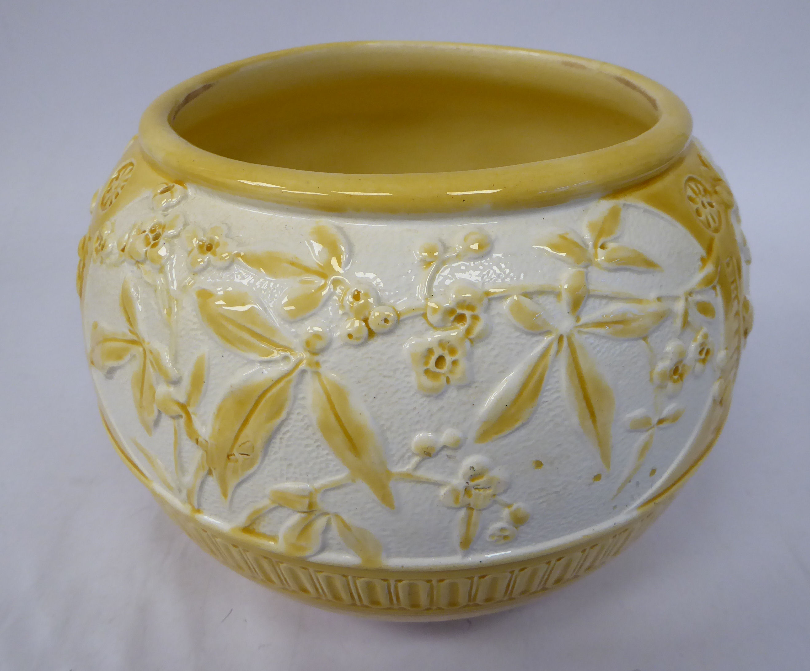An early 20thC Burmantofts sand coloured and white glazed earthenware jardiniere of bulbous form,