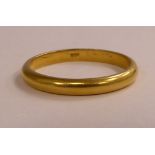 A gold coloured metal wedding ring stamped 900